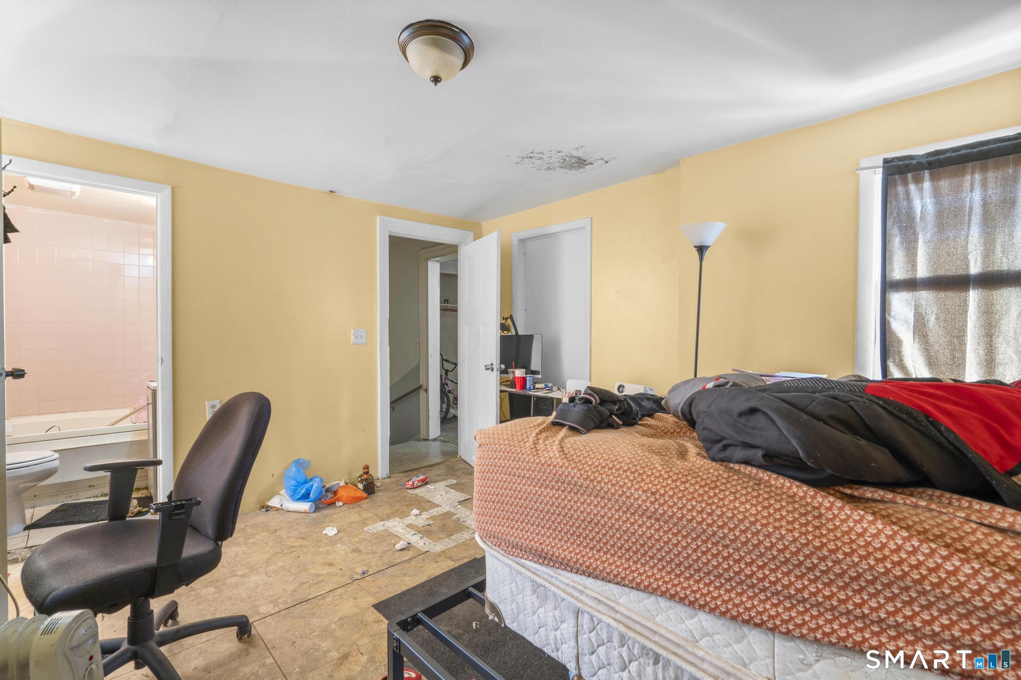349 Noble Avenue Bridgeport, CT 06608 - Photo 11 of 33 a bedroom with a bed and a chair