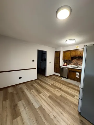 a view of kitchen with cabinets and refrigerator