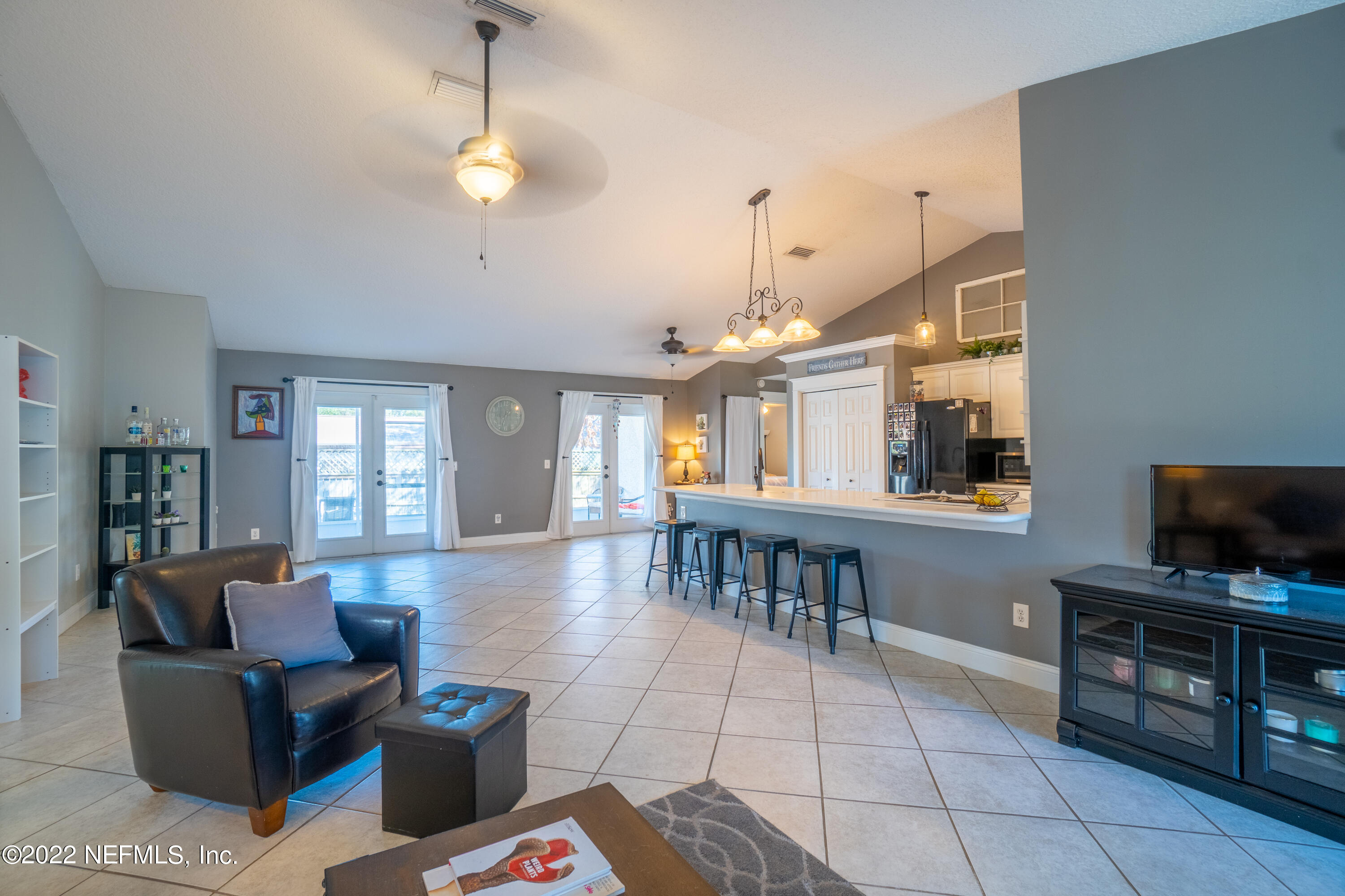115 Nautilus Road St. Augustine, FL 32086 - Photo 5 of 23 a living room with furniture a flat screen tv and kitchen view
