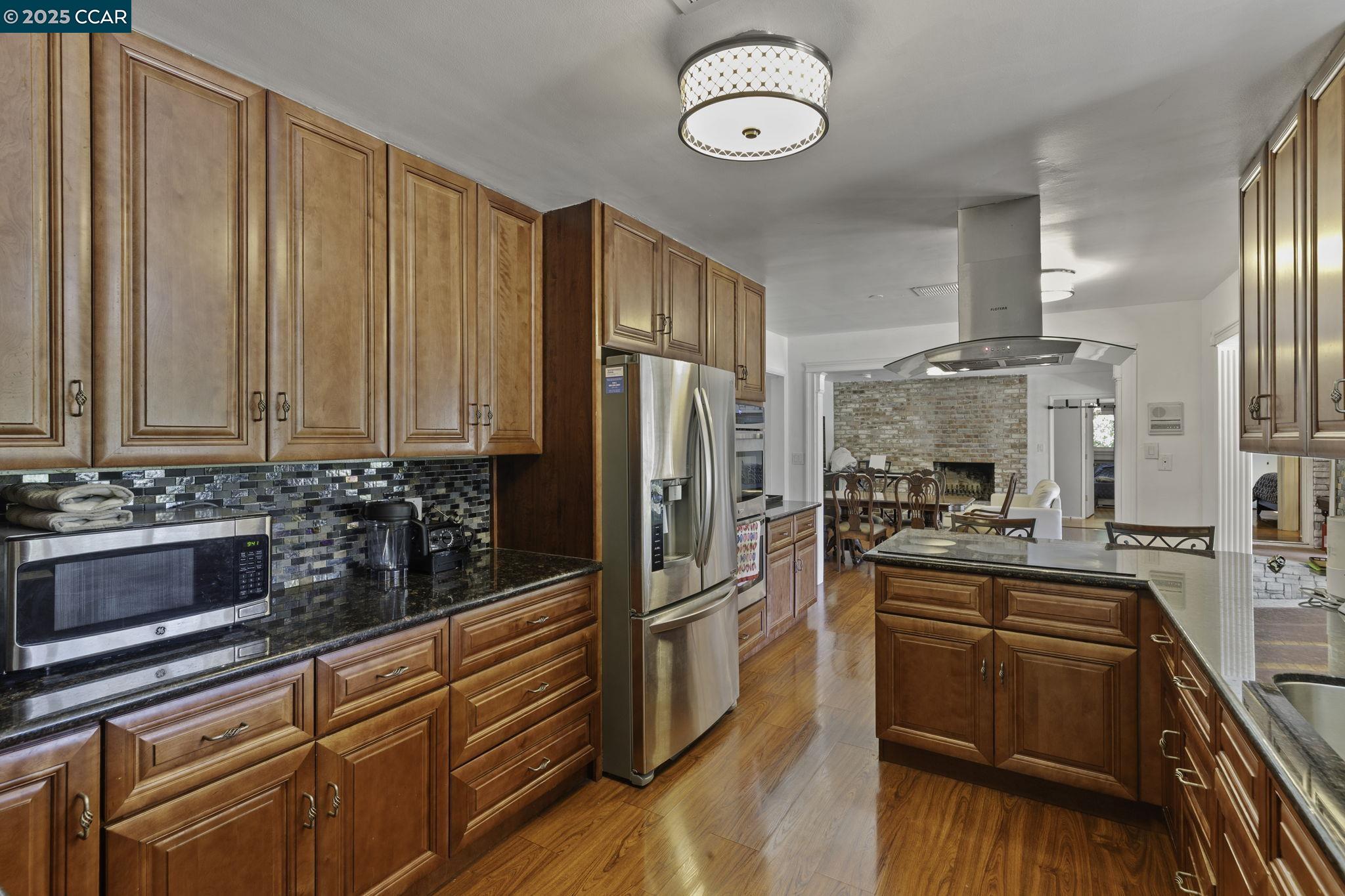 1910 San Miguel Drive Walnut Creek, CA 94596 - Photo 17 of 58 a kitchen with stainless steel appliances wooden cabinets and a refrigerator