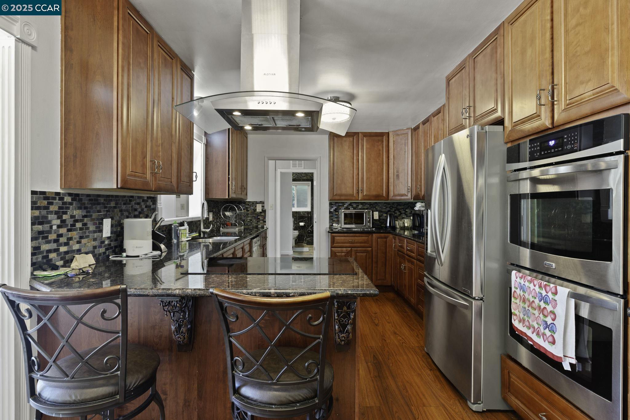 1910 San Miguel Drive Walnut Creek, CA 94596 - Photo 20 of 58 a kitchen with stainless steel appliances granite countertop a stove a sink dishwasher and cabinets with wooden floor