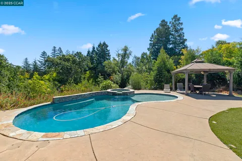 an aerial view of a houses with a street and green space