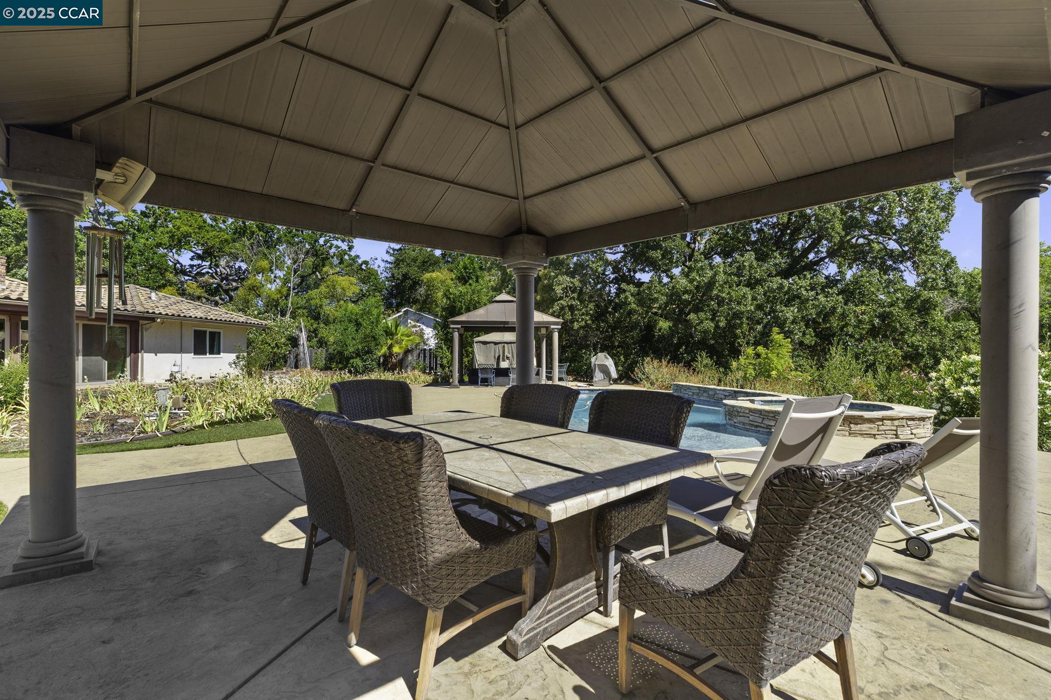 1910 San Miguel Drive Walnut Creek, CA 94596 - Photo 36 of 58 a view of an outdoor dining space with a table and chairs under an umbrella