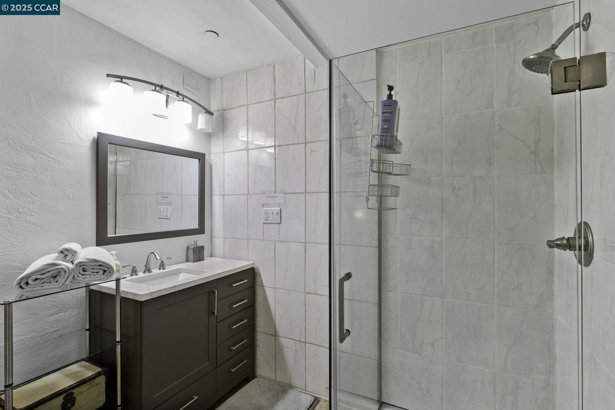 1910 San Miguel Drive Walnut Creek, CA 94596 - Photo 56 of 58 a bathroom with a mirror vanity and a shower