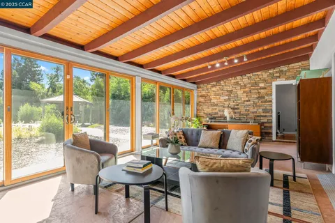 a living room with patio furniture and a large window