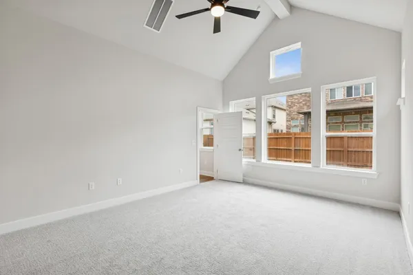 an empty room with windows and ceiling fan