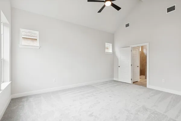 an empty room with a ceiling fan and window