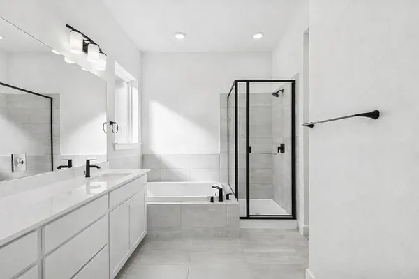 a spacious bathroom with a tub a sink and mirror