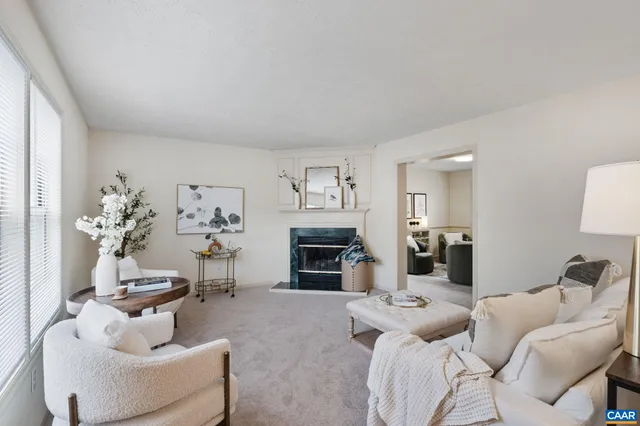 a living room with furniture a fireplace and a large window