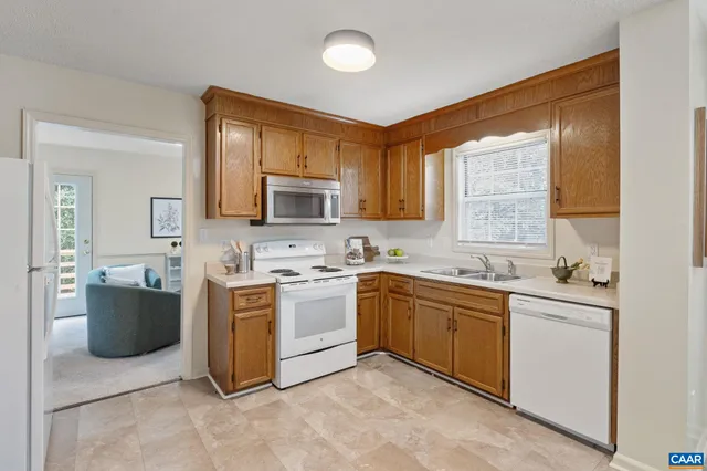 a kitchen with stainless steel appliances granite countertop a stove top oven a sink dishwasher a refrigerator and a microwave