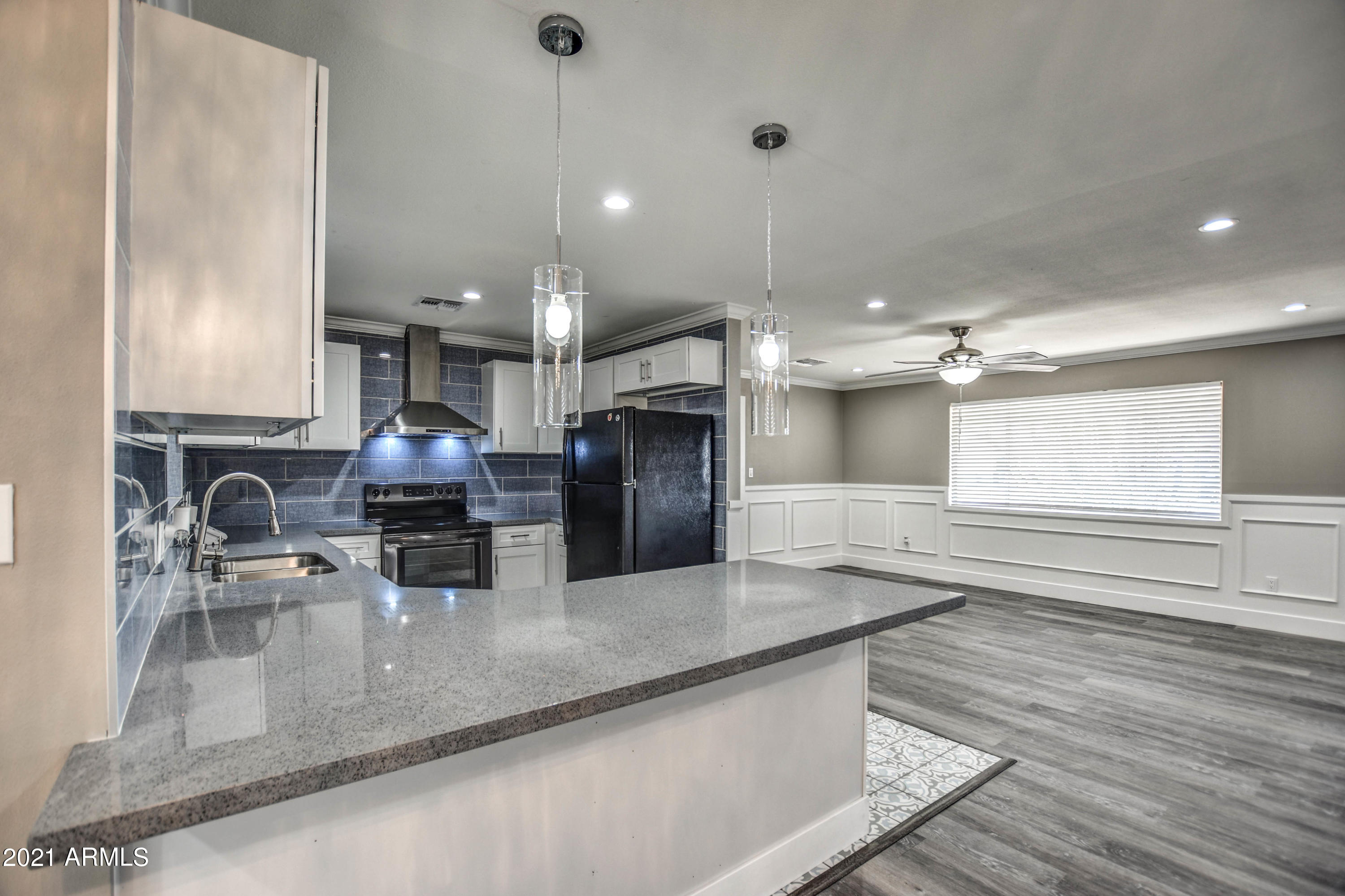 5743 Casper Road Mesa, AZ 85205 - Photo 6 of 43 a kitchen with stainless steel appliances granite countertop a sink a stove and a wooden floors