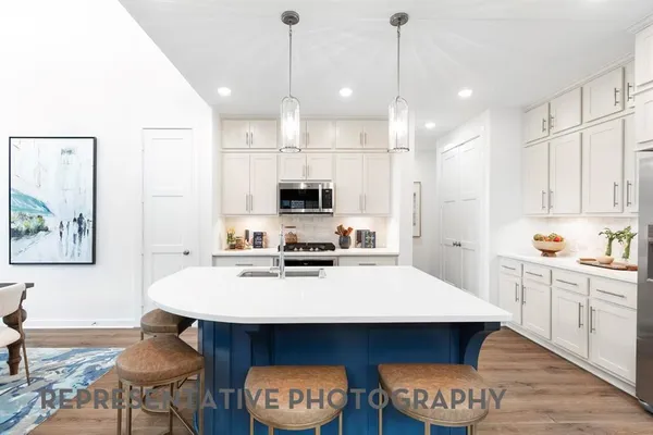 a kitchen with stainless steel appliances a stove a sink a refrigerator a dining table and chairs