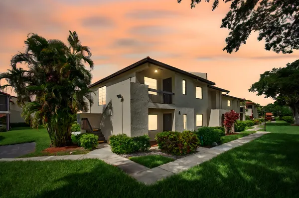 a view of a hallway with wooden floor and a bathroom