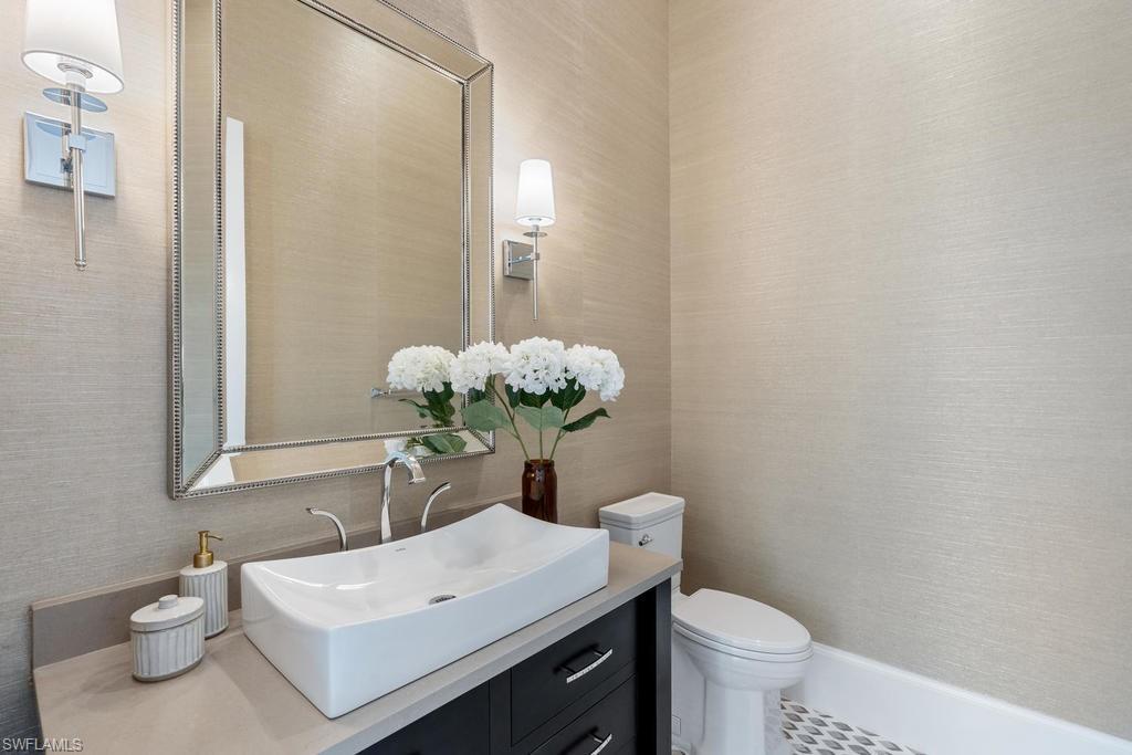 4478 Wayside Drive Naples, FL 34119 - Photo 15 of 31 a bathroom with a sink a toilet and a mirror