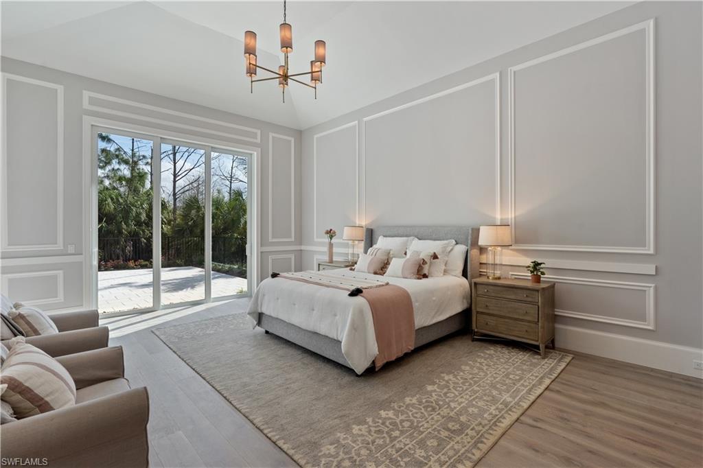 4478 Wayside Drive Naples, FL 34119 - Photo 20 of 31 a spacious bedroom with a bed and glass window