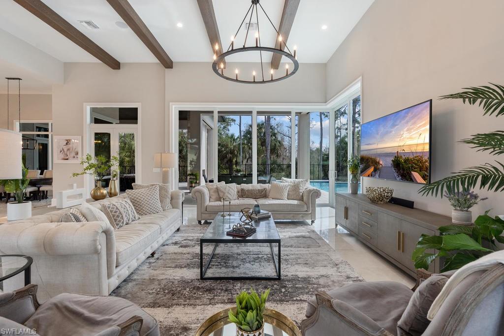 4478 Wayside Drive Naples, FL 34119 - Photo 3 of 31 a living room with furniture a flat screen tv and a large window