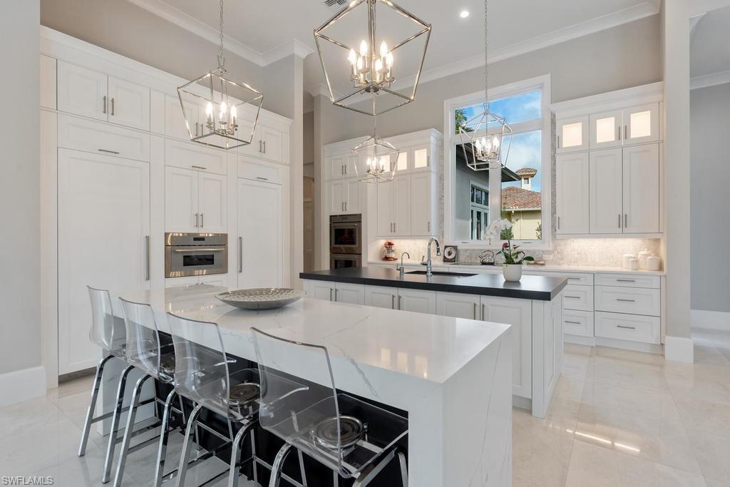 4478 Wayside Drive Naples, FL 34119 - Photo 4 of 31 a kitchen with kitchen island granite countertop a table and chairs in it