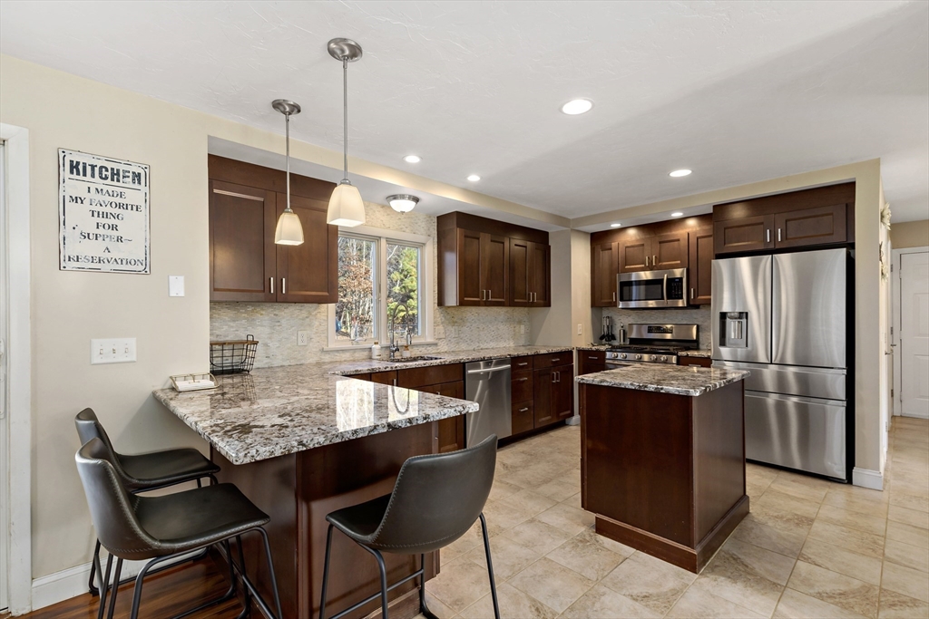 19 Oakbluff Road Bourne, MA 02562 - Photo 22 of 42 a kitchen with stainless steel appliances granite countertop a stove a refrigerator a kitchen island a sink dishwasher and a refrigerator