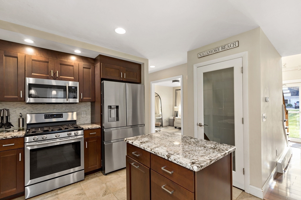 19 Oakbluff Road Bourne, MA 02562 - Photo 25 of 42 a kitchen with stainless steel appliances kitchen island granite countertop a stove refrigerator and microwave