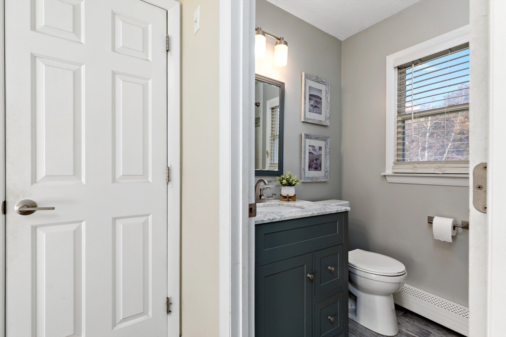 19 Oakbluff Road Bourne, MA 02562 - Photo 39 of 42 a bathroom with a granite countertop toilet a sink a mirror and a window