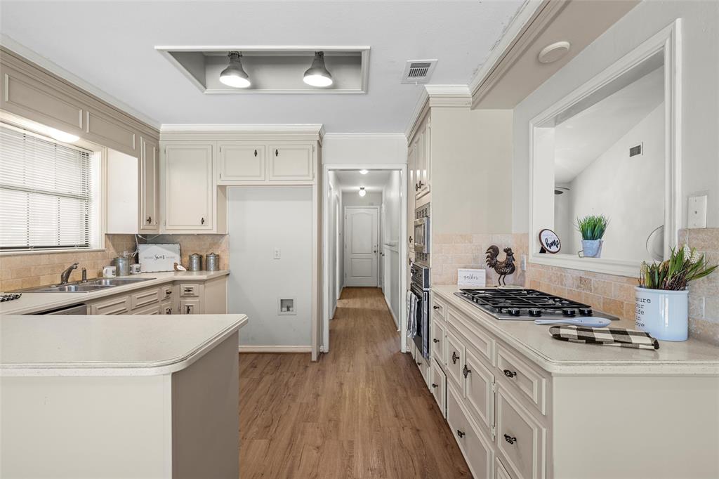 3601 Willow Bend Circle Waco, TX 76708 - Photo 10 of 37 a kitchen with stainless steel appliances a white cabinets stove and wooden floors