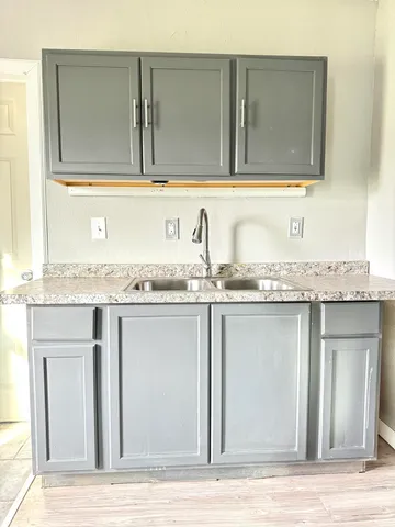 a view of a kitchen sink granite counter top and cabinets