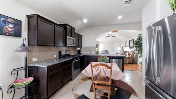 a kitchen with stainless steel appliances granite countertop a stove refrigerator sink and cabinets