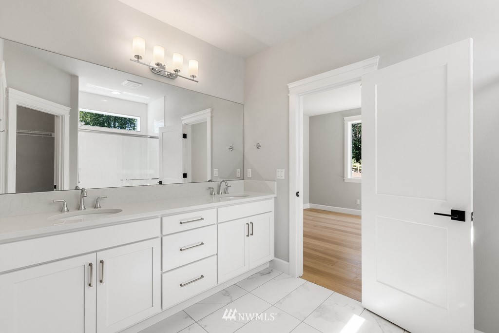 22921 31st Avenue Southeast Bothell, WA 98021 - Photo 10 of 16 a spacious bathroom with a granite countertop sink a mirror and a shower