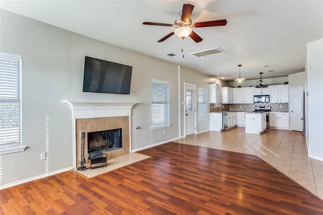a view of a room with wooden floor and a kitchen