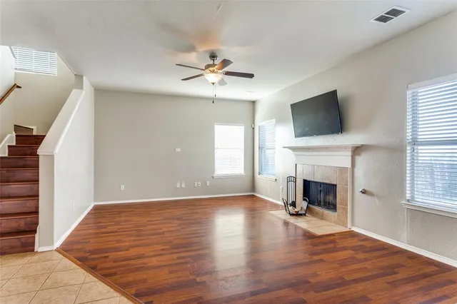 a view of empty room with fireplace fan and windows
