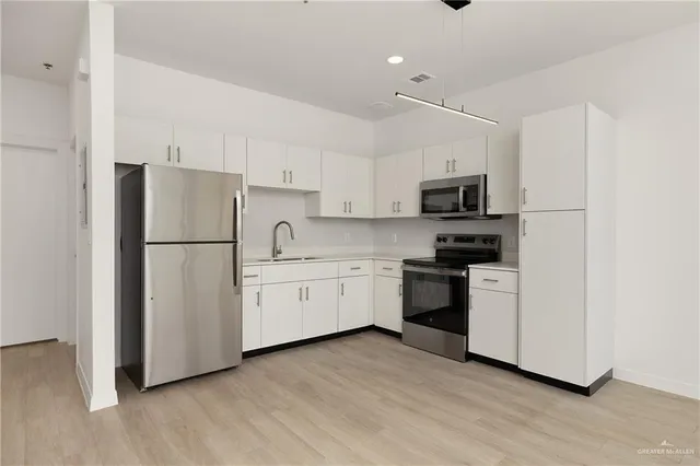 a kitchen with stainless steel appliances white cabinets and a refrigerator