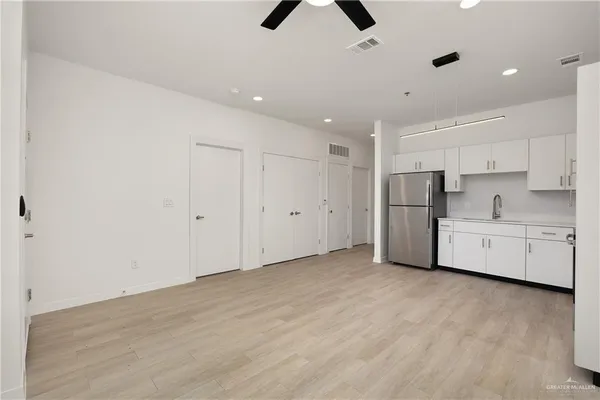 a view of kitchen with stainless steel appliances refrigerator oven and cabinets