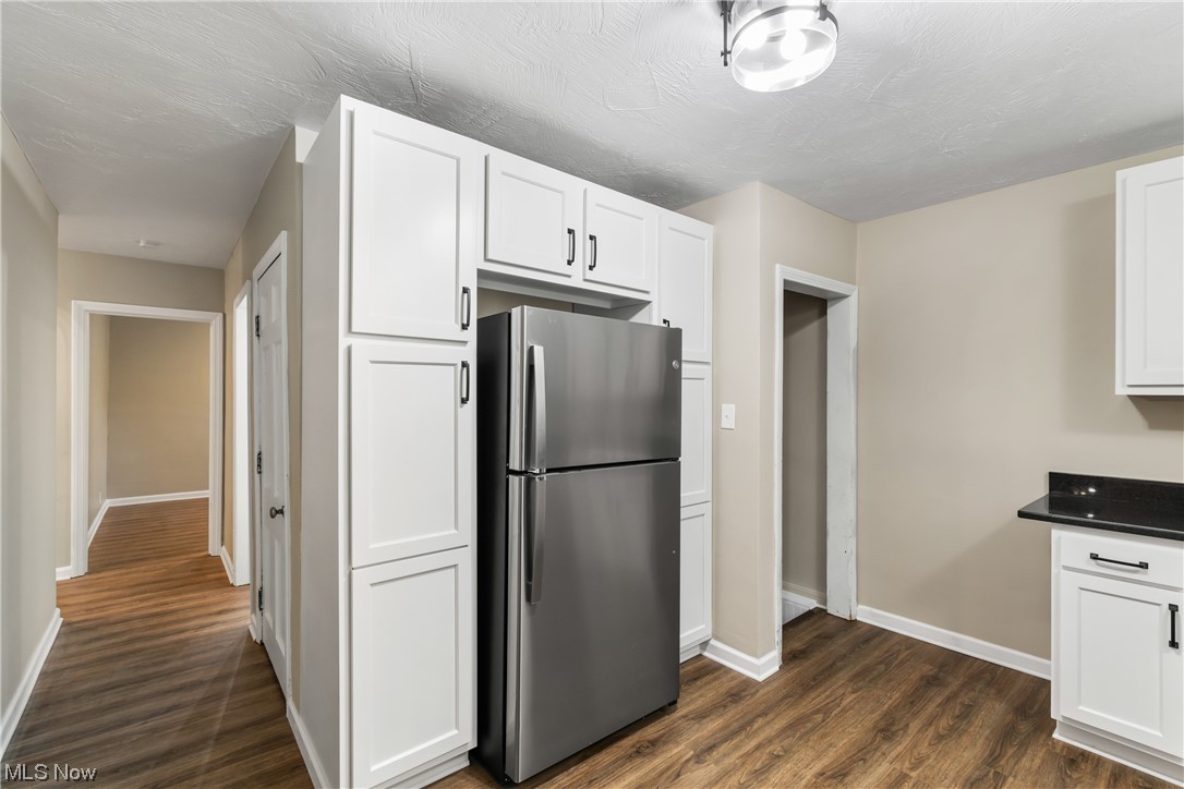 916 Renninger Road Akron, OH 44319 - Photo 11 of 31 Kitchen featuring dark wood-type flooring, stainless steel refrigerator, and white cabinets