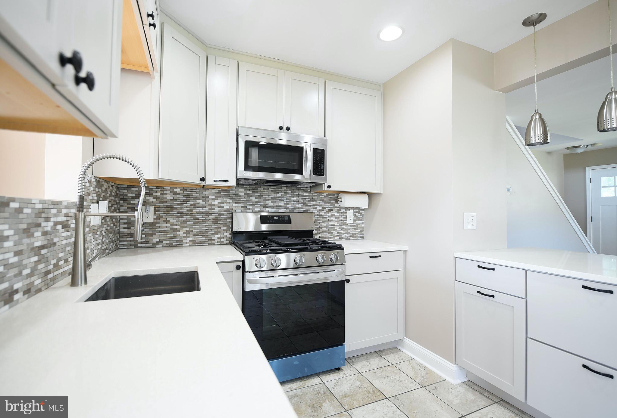 8205 Oakleigh Road Baltimore, MD 21234 - Photo 15 of 52 a kitchen with a stove a sink and a microwave