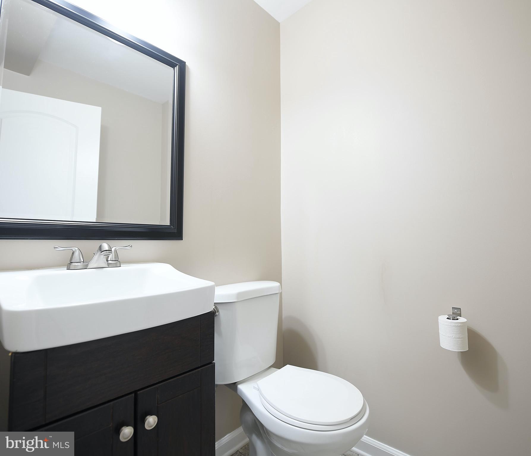8205 Oakleigh Road Baltimore, MD 21234 - Photo 21 of 52 a bathroom with a sink a toilet a mirror and vanity