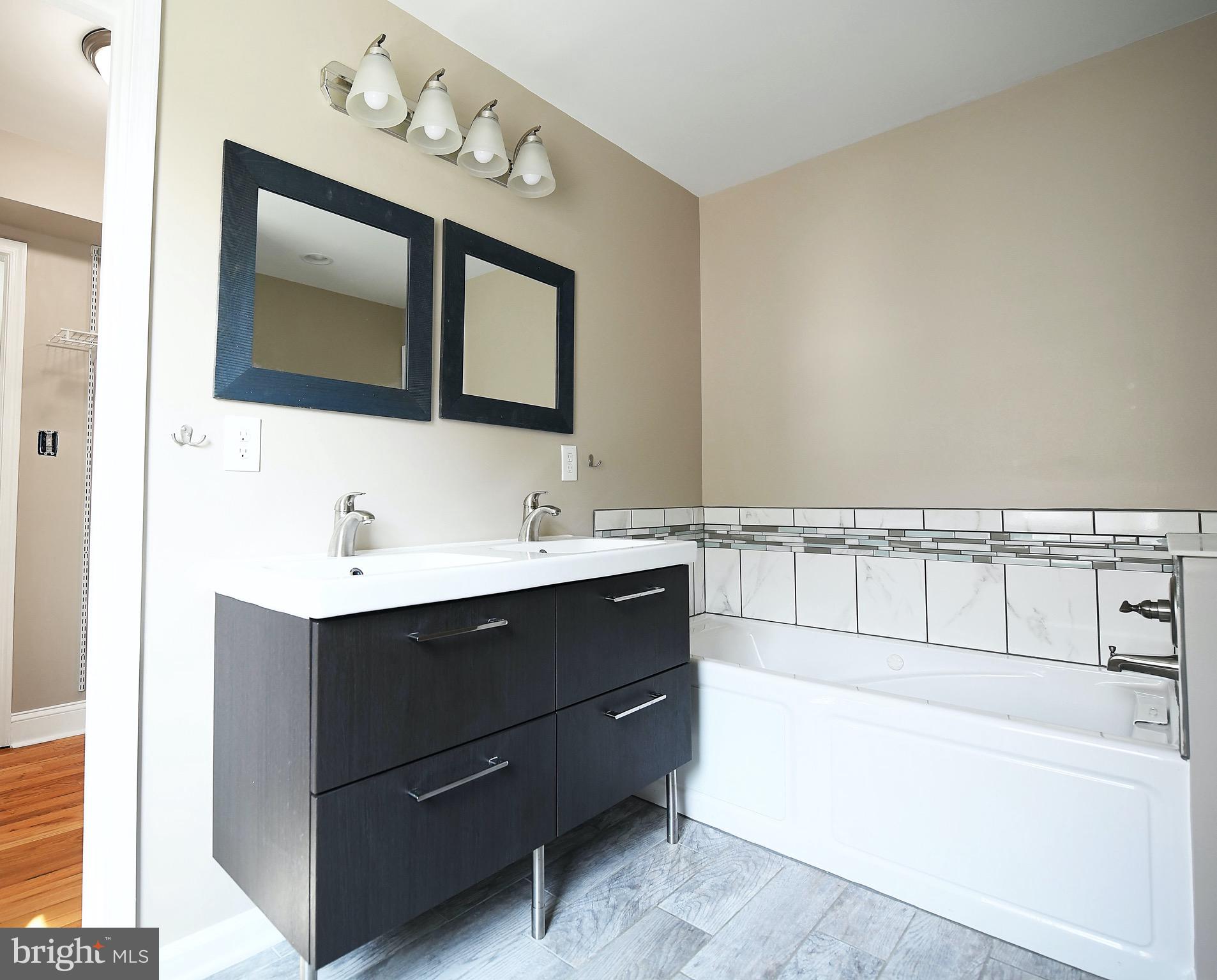 8205 Oakleigh Road Baltimore, MD 21234 - Photo 25 of 52 a bathroom with a sink vanity tub and mirror