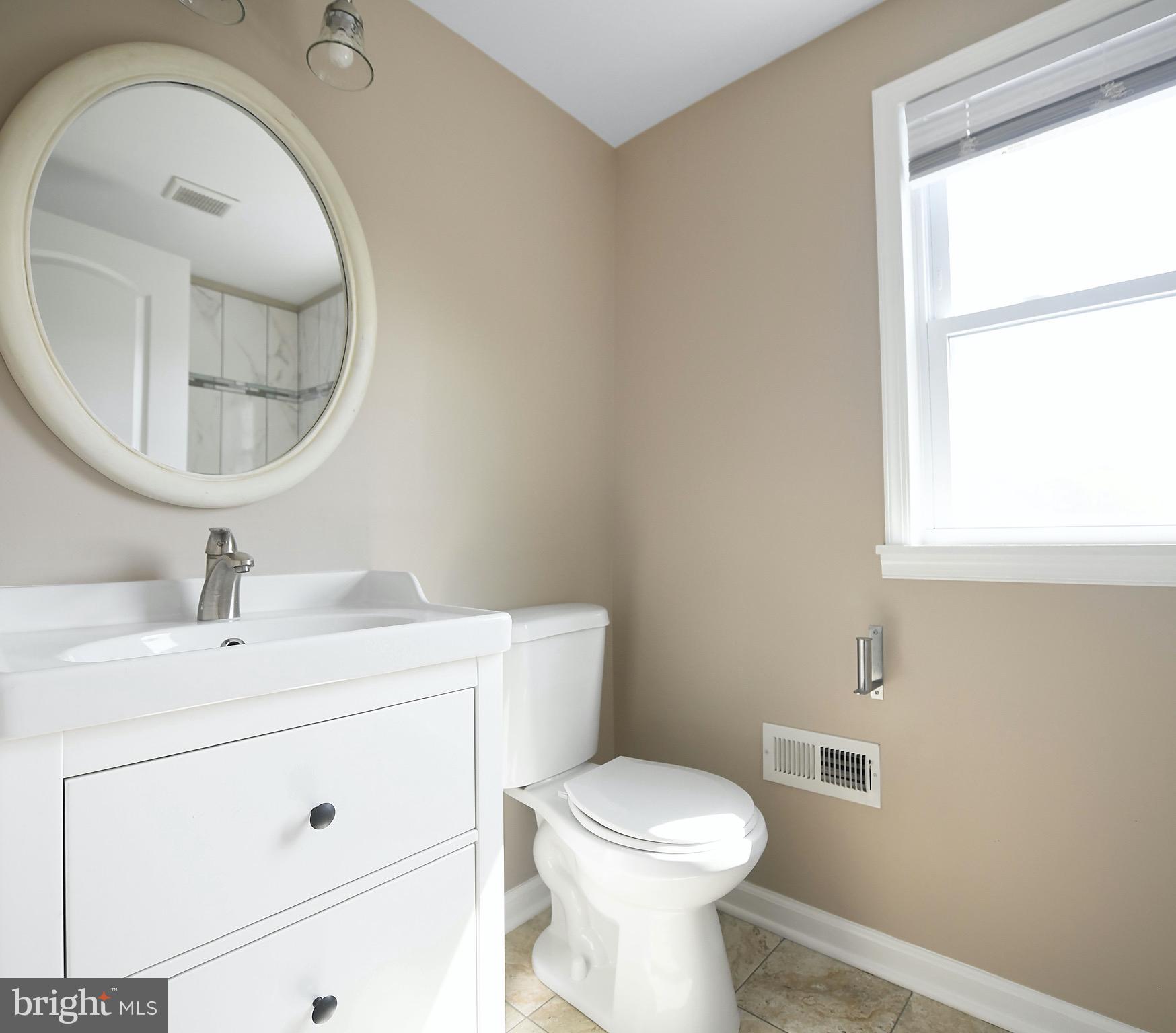 8205 Oakleigh Road Baltimore, MD 21234 - Photo 32 of 52 a bathroom with a toilet sink and mirror