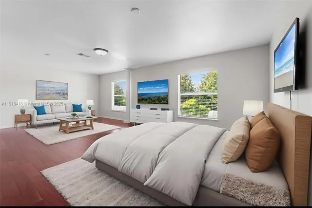 a bedroom with a bed a window and a television