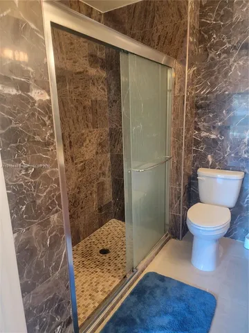 a bathroom with a toilet and a shower