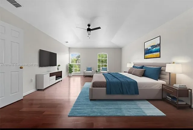 a bedroom with a large bed a flat screen tv and a couch