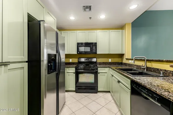 a kitchen with a sink a refrigerator and a stove top oven
