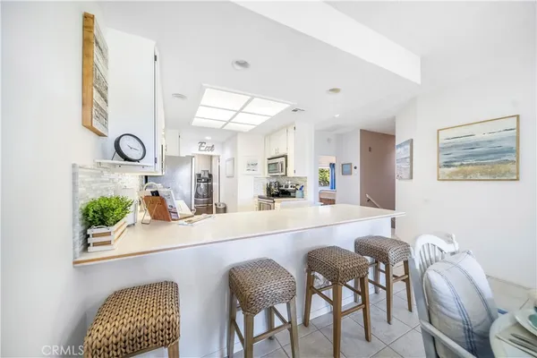 a large white kitchen with a table and chairs