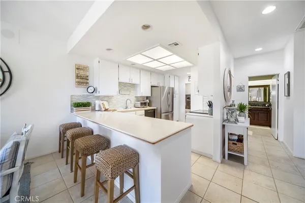 a kitchen with stainless steel appliances kitchen island granite countertop a table and chairs in it