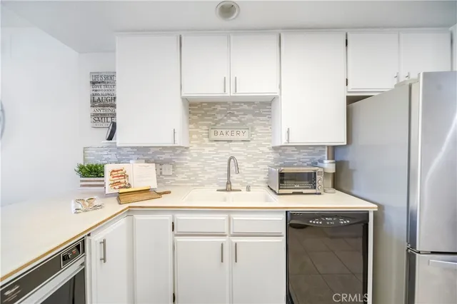 a kitchen with stainless steel appliances white cabinets and a refrigerator