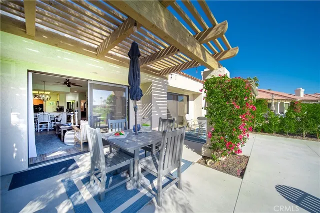 a view of patio with a table and chairs and potted plants