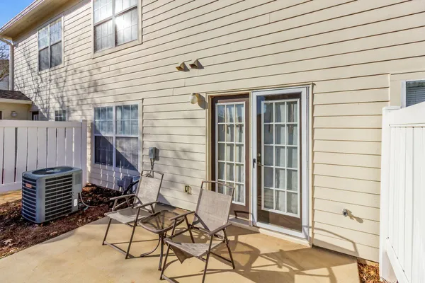 a view of a patio with chair and table and chairs and wooden fence