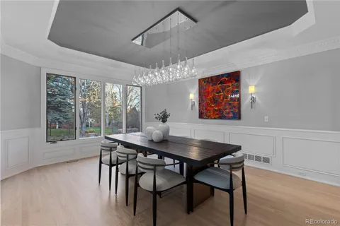 a dining room with furniture a chandelier and wooden floor
