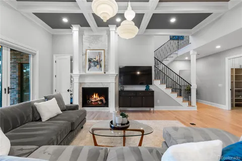 a living room with furniture a fireplace and a chandelier