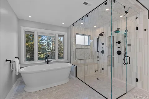 a bathroom with a tub shower and mirror