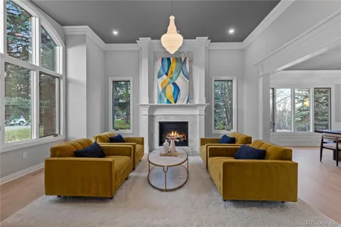 a living room with furniture a floor to ceiling window and fireplace